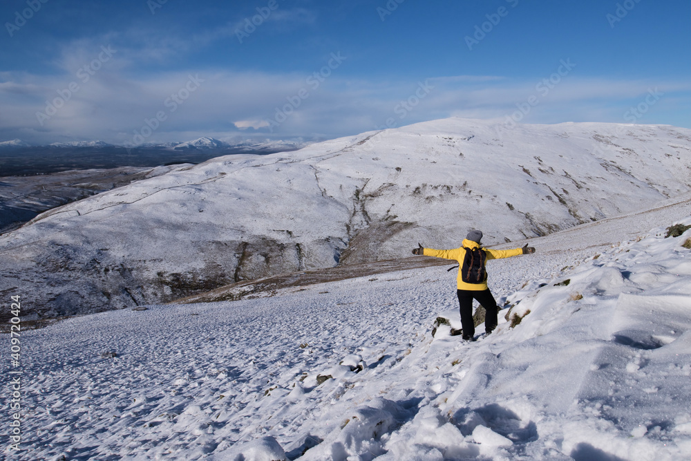 Φωτογραφία hiker girl in the snow covered hills wearing a yellow jacket and enjoying the Oc