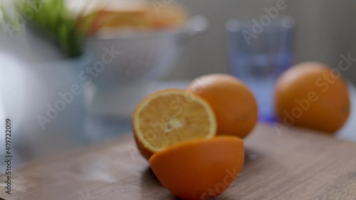 Cutting oranges in half on the table. Home kitchen. Soft focus in the background 