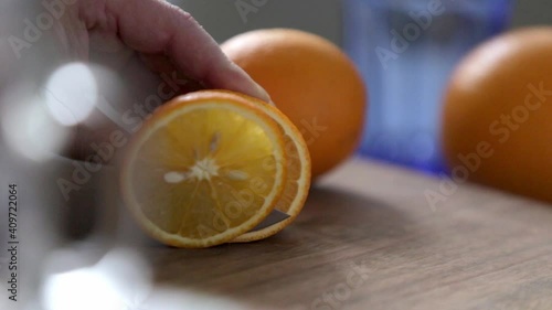 Cutting an orange into slices on a table. Home kitchen. Soft focus in the background. Close up