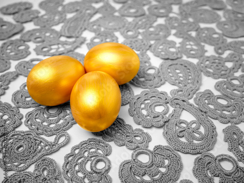 Golden Easter eggs on vintage lace background. The concept of a bright Easter