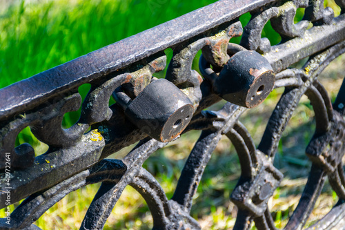 Old rusty metal fence, bokeh, green Gothic background. Vintage fence, vintage fence.