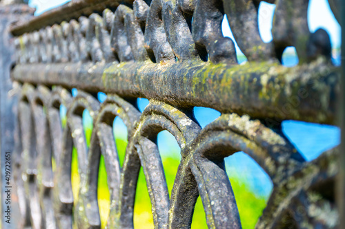 Old rusty metal fence, bokeh, green Gothic background. Vintage fence, vintage fence.