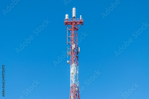 symbolizing the modern way of messaging and communication. the receiving antenna of the TV signal. blue sky background. steel truss tower with service platforms. against the blue sky. 