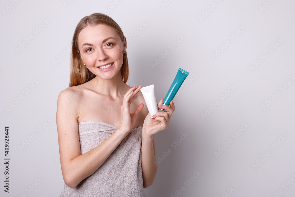attractive girl with bottles of cream in her hands on a white background attractive girl with bottles of cream in her hands on a white background