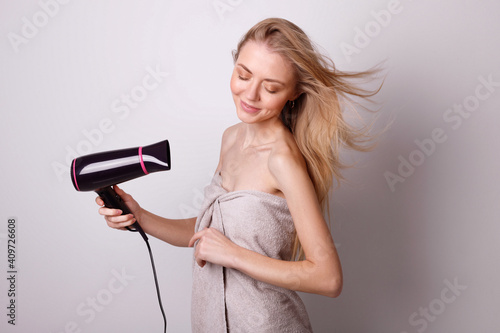 Attractive girl with hair dryer. hair care