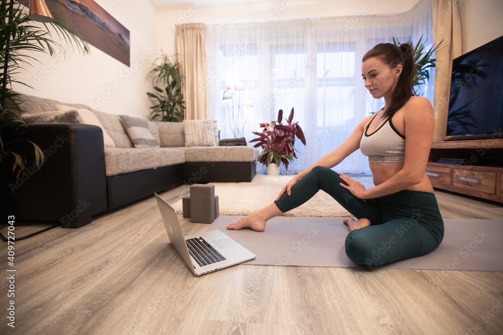 © Lukas Gojda - Pretty woman is doing fitness at home on living room floor. Fitness, workout and healthy living concept.
