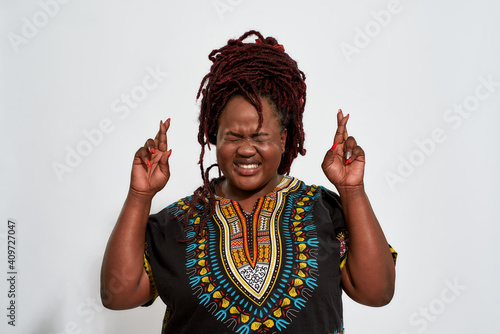 Canvas Print Happy plump woman holding crossed fingers and closed eyes