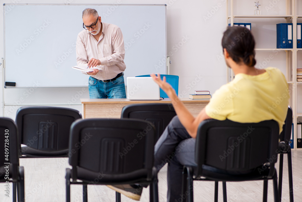 Young male student and experienced teacher in pandemic concept Young male student and experienced teacher in pandemic concept