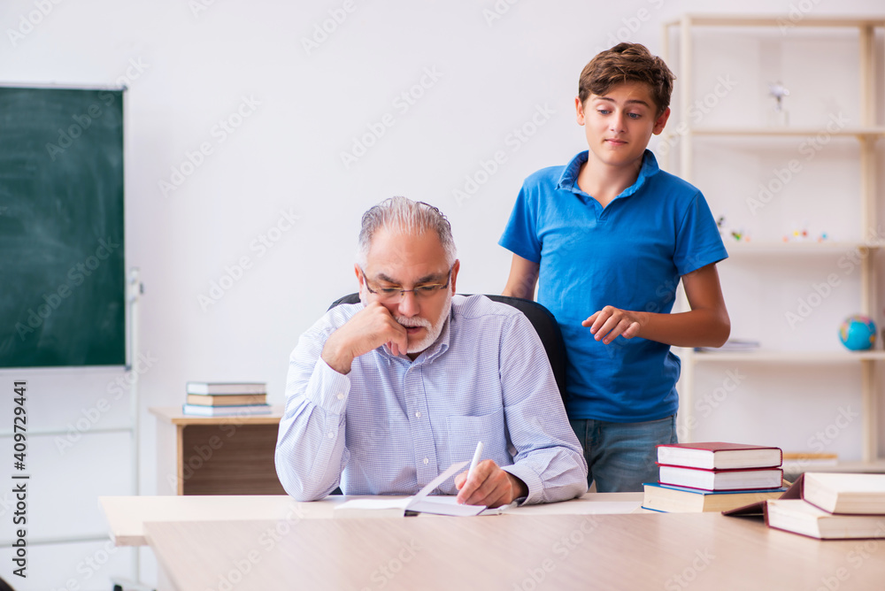 Old male teacher and schoolboy in the classroom Old male teacher and schoolboy in the classroom