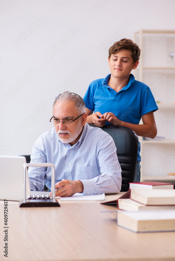 Obraz premium Old male teacher and schoolboy in the classroom