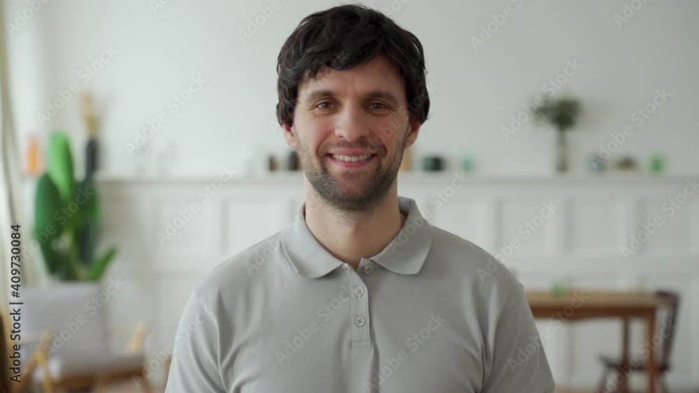 Portrait of a happy man in a gray shirt looking at the camera and smiling Portrait of a happy man in a gray shirt looking at the camera and smiling