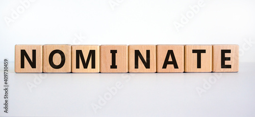Nominate symbol. Wooden cubes with word 'nominate'. Beautiful white background. Business, psychology and nominate concept. Copy space. photo