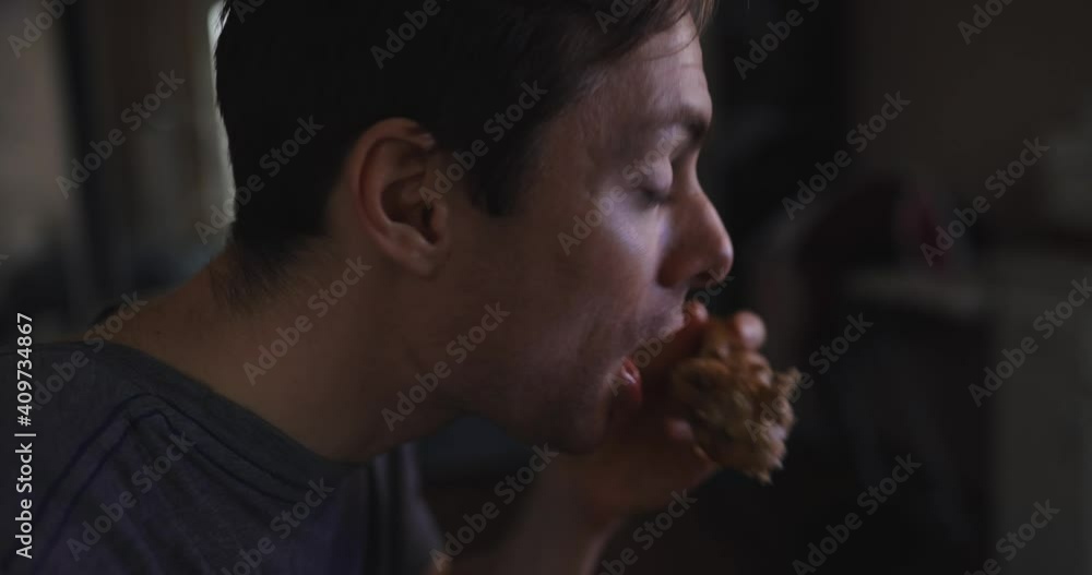 Young man eats meat and watches tv at home Young man eats meat and watches tv at home