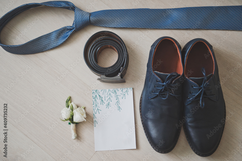 Wedding details: belt, wedding invitation, boutonniere, grooms tie and s Wedding details: belt, wedding invitation, boutonniere, grooms tie and s