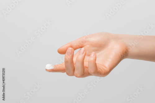 Obraz na plátne A drop of thick white hand cream on the finger of a woman's hand