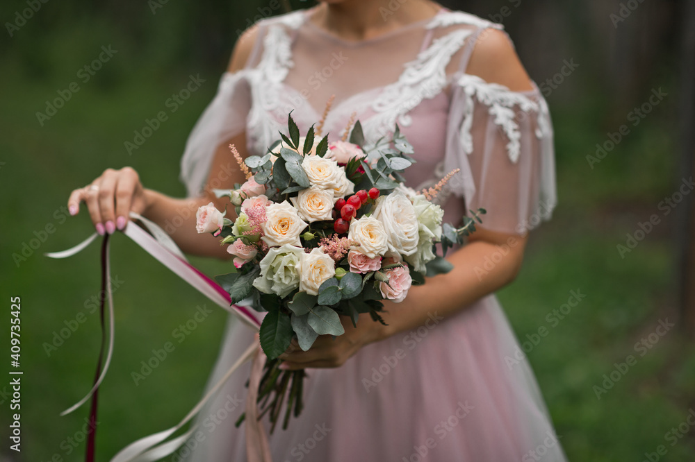 Disheveled delicate wedding bouquet in the hands of the bride of roses a Disheveled delicate wedding bouquet in the hands of the bride of roses a