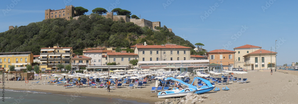 Panorama of Castiglione della Pescaia from the pier at the mouth of the Bruna river. In the foreground the beach and in the background the upper part of the village with the walls and the castle.