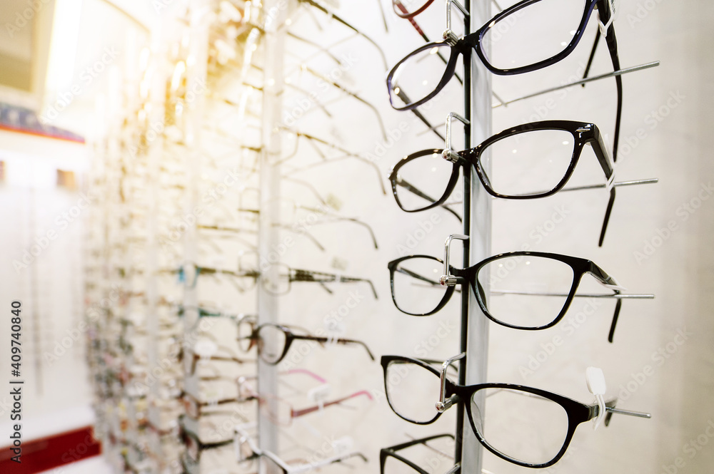 Row of glasses at an opticians. Eyeglasses shop. Stand with glasses in the store of optics. Row of glasses at an opticians. Eyeglasses shop. Stand with glasses in the store of optics.
