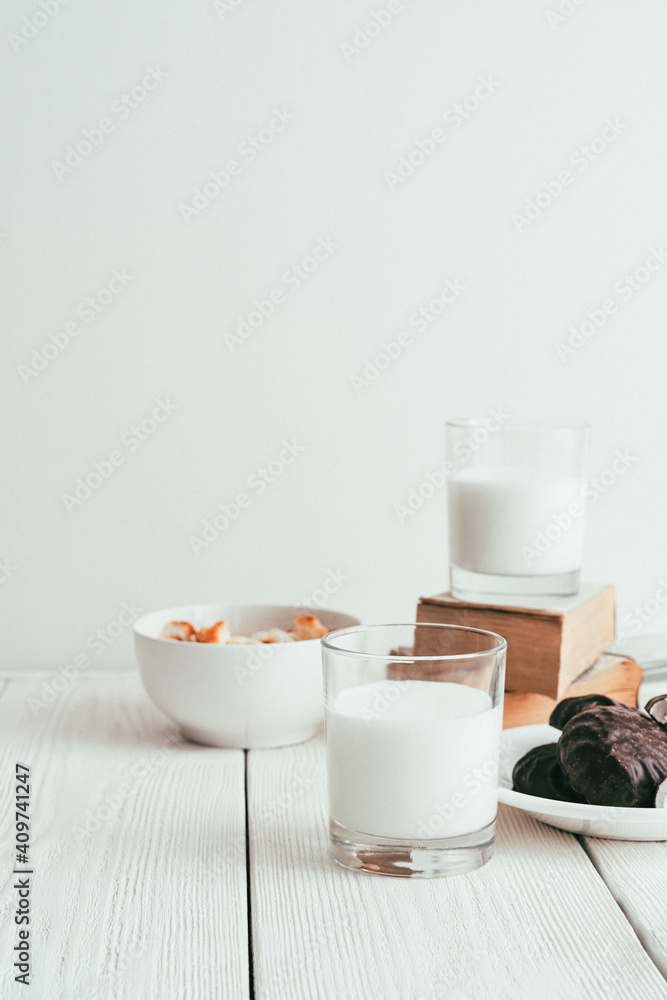Milk in a glass, marshmallows and crackers on a white background. Side view vertical orientation. Tinted in vintage style. Milk in a glass, marshmallows and crackers on a white background. Side view vertical orientation. Tinted in vintage style.