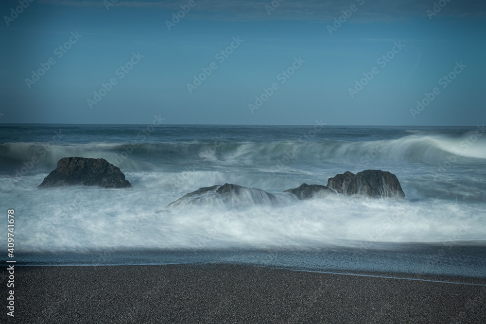 Waves coming towards the beach, long exposure on a blue sky day with no clouds, and lots of copy-space, Schoolhouse Beach in Sonoma County, CA, USA