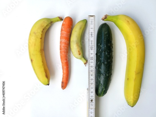 Measuring tape with bananas, carrot an cucumber symbolizing different penis sizes and forms