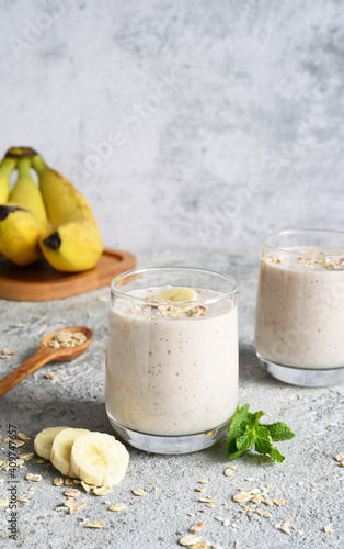 Smoothie with banana and oatmeal for breakfast on a light concrete background. Detox menu.