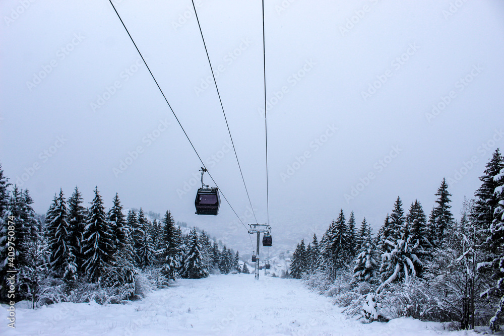 Obraz premium Cable car photographed from Trebevic in winter while it is snowing. Snow in winter on the mountain Trebevic. Sarajevo cable car in nature. Winter and snow.