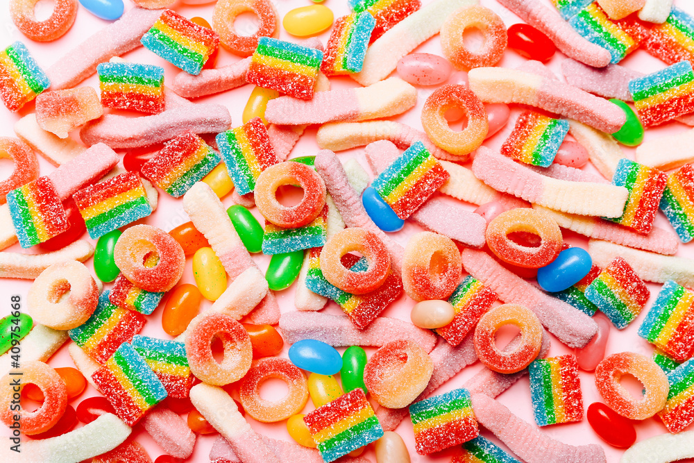 Mixed collection of colorful candy, on pink background. Flat lay, top view