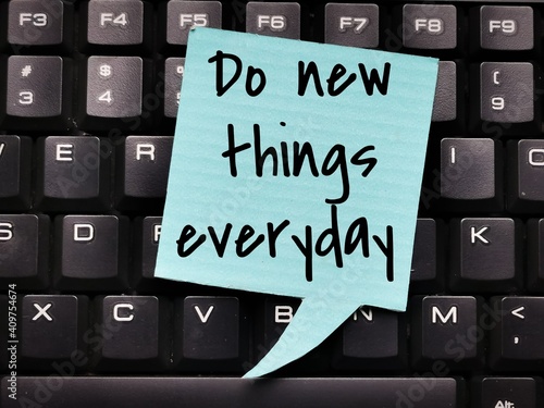 Motivational quote.Top view bubble speech written Do new things everyday on computer keyboard.