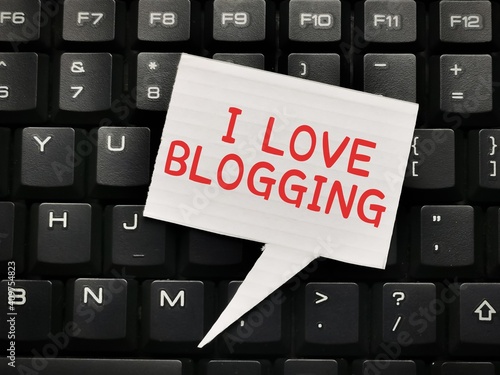 Blogging concept.Top view white bubble speech written I LOVE BLOGGING on computer keyboard.