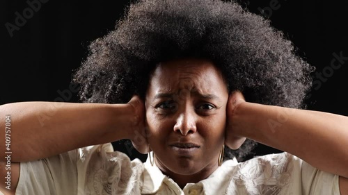 [4k] stressed black woman holding hands on ears to stop hearing racism
