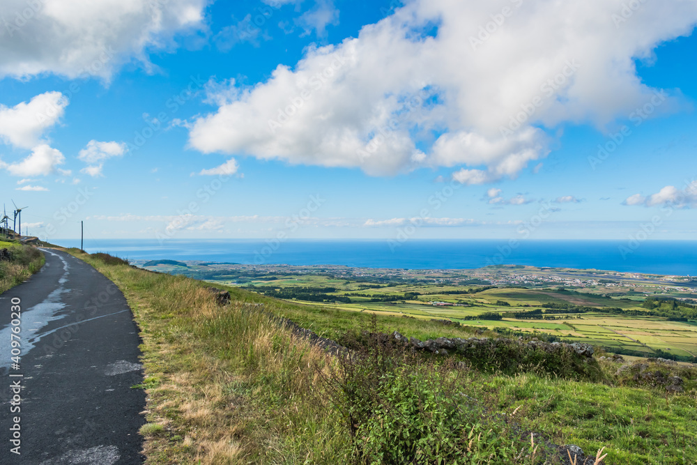 Serra do Cume with grass and stone wall with road overlooking the Atlantic Ocean, Terceira - Azores PORTUGAL