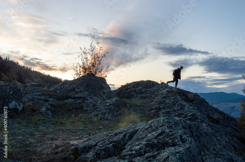 Silhouette of man hiking with sunset