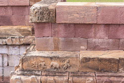 Aihole, Karnataka, India - November 7, 2013: Huchchimalli Gudi or Temple. Closeup of small brown stone fresco on red stone wall of tank. photo