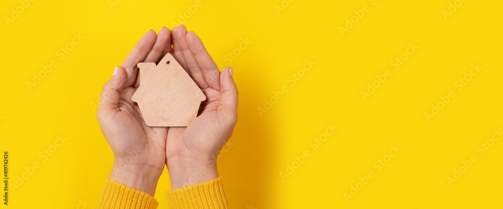 house toy in hands over yellow background, panoramic mock-up - obrazy, fototapety, plakaty 