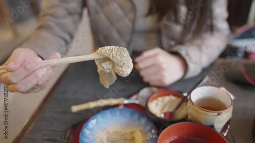 Warabi Mochi, covered in Kinako Soybean flour being held by Japanese Woman photo