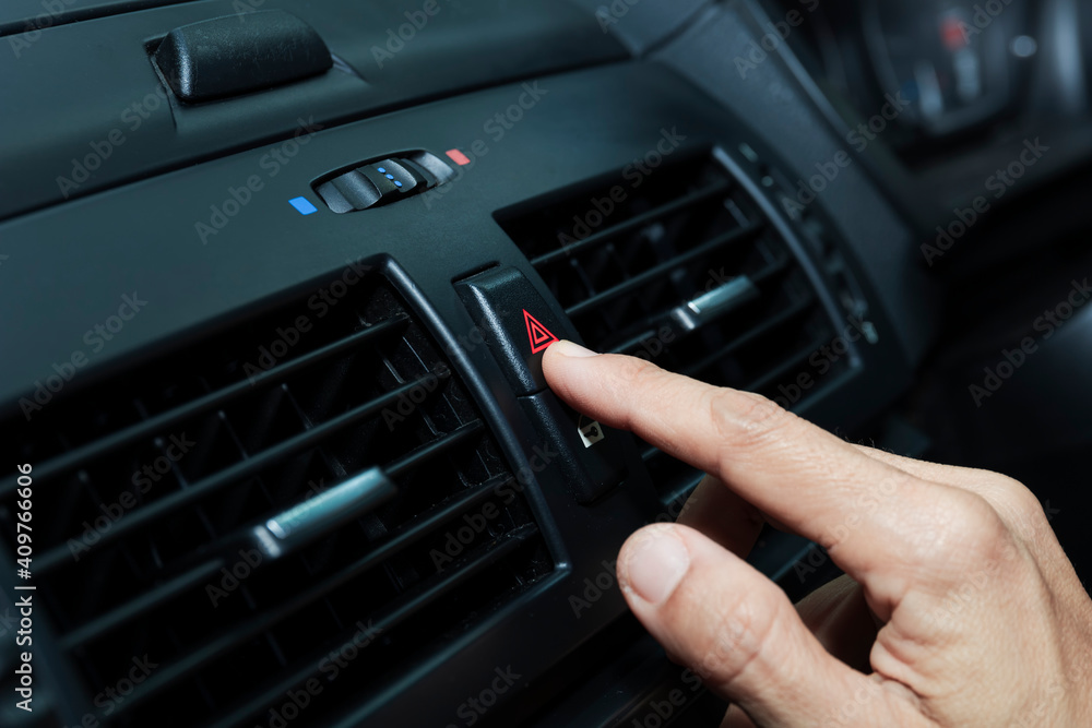 Close up hand press the emergency light in the car, Fingers press button.for open the contract emergency light in car. Emergency button press for open emergency light warning sign symbol out side car Close up hand press the emergency light in the car, Fingers press button.for open the contract emergency light in car. Emergency button press for open emergency light warning sign symbol out side car