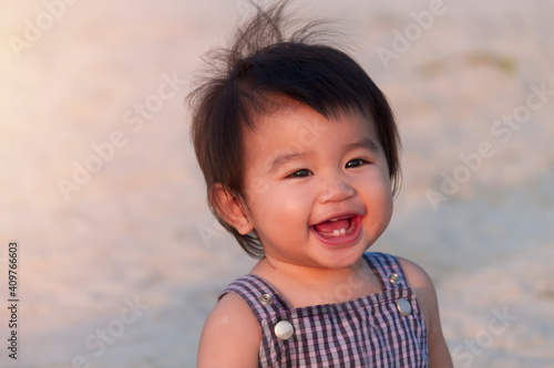Close up portrait little girl. Cute adorable asian little girl play in park with sun ray background. Happy baby girl play in outdoor park. Close up and soft focus baby gril.