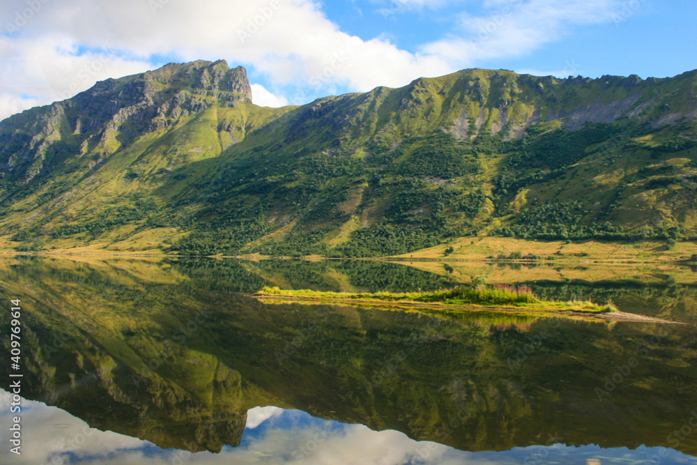 Wonderful panorama of Norwegian mountains and rocks that are reflected in the water.