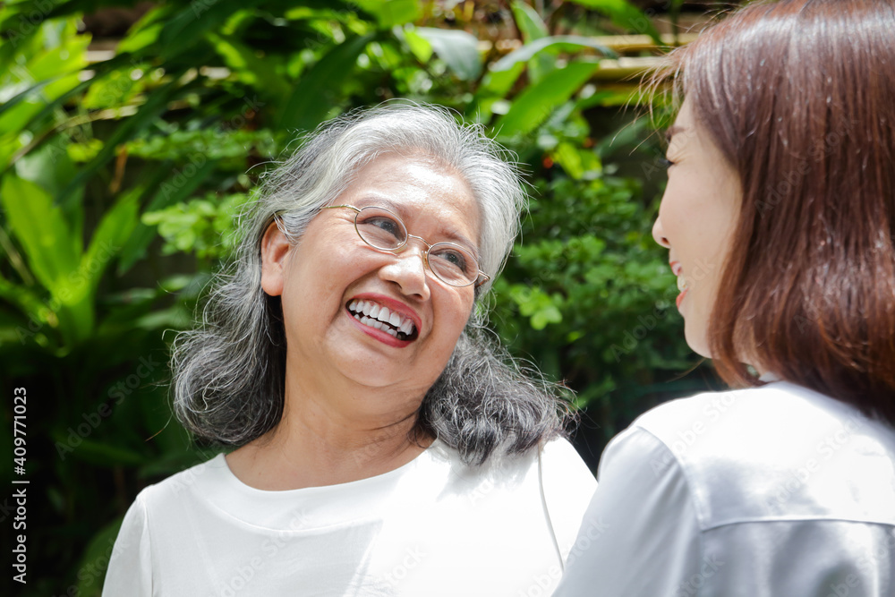 Daughter caring for elderly Asian mother Both of them exercised in the front garden. Make it healthy, strong, a happy family. Senior care concept in retirement age Daughter caring for elderly Asian mother Both of them exercised in the front garden. Make it healthy, strong, a happy family. Senior care concept in retirement age