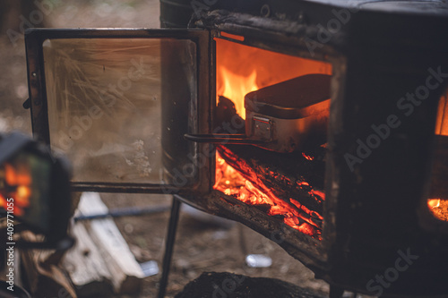 冬のキャンプ。野外で薪ストーブのアウトドア料理。