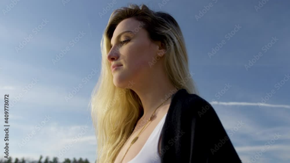 Strong young woman looks confidently into the golden sunset. Close up shot, orbital. Strong young woman looks confidently into the golden sunset. Close up shot, orbital.