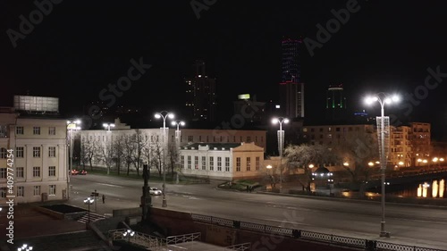 Yekaterinburg, Russia, Lenina street at night. Stock footage. Aerial view of an empty wide city street with lanterns on the background of black sky and skyscrapers. photo