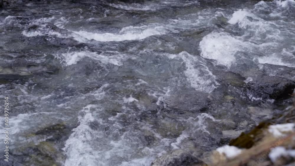 Slow motion pan of fast moving river in winter Slow motion pan of fast moving river in winter
