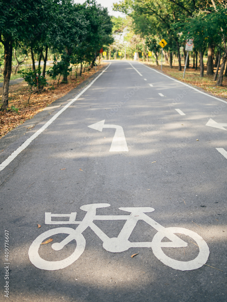 Obraz premium cycling path in the park. bicycle traffic sign painted on the floor