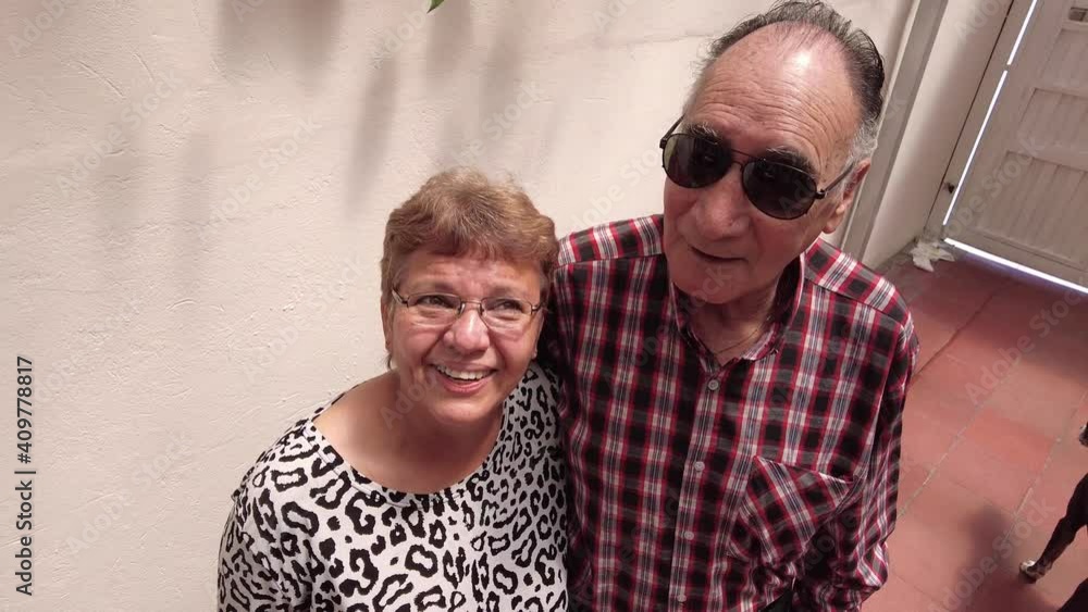 High angle scene of elderly or senior couple smiling. woman or wife wearing a animal print blouse and man or husband with red plaid shirt. Parents or grandparents natural family scene. Natural models. High angle scene of elderly or senior couple smiling. woman or wife wearing a animal print blouse and man or husband with red plaid shirt. Parents or grandparents natural family scene. Natural models.