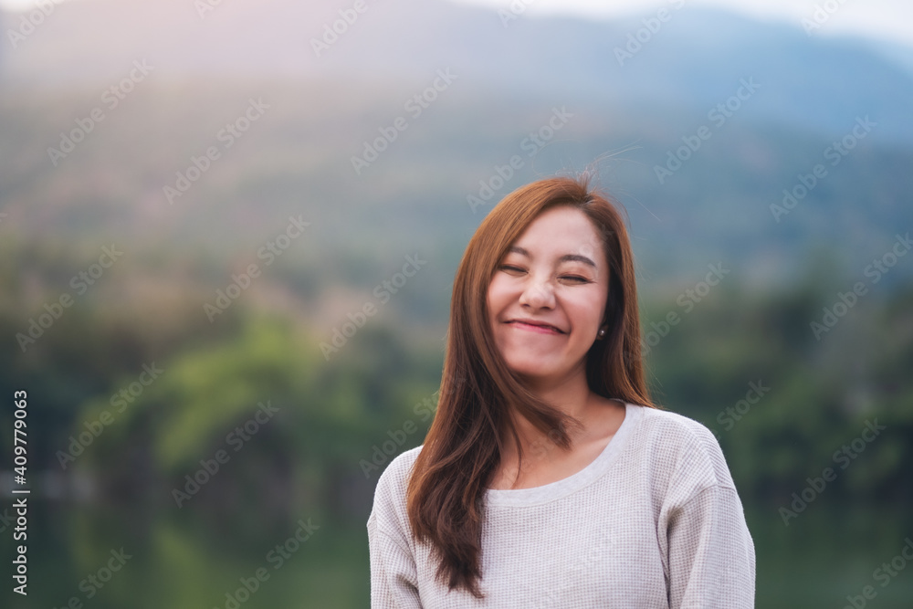 Portrait image of a beautiful young asian woman standing in front of the lake and mountains Portrait image of a beautiful young asian woman standing in front of the lake and mountains