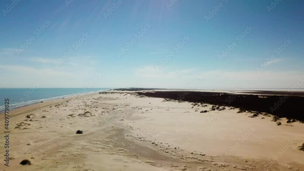 Drone - rising, reveal view of the shoreline and sand dunes on a gulf coast barrier island on a sunny afternoon, fisherman and vehicles in the distance - South Padre Island, Texas Drone - rising, reveal view of the shoreline and sand dunes on a gulf coast barrier island on a sunny afternoon, fisherman and vehicles in the distance - South Padre Island, Texas
