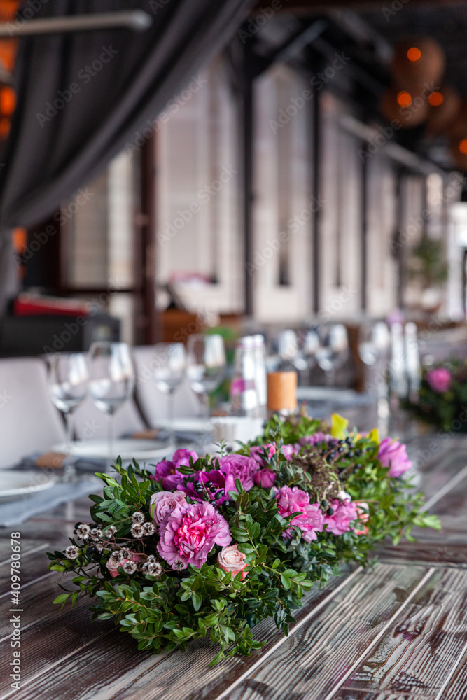 Modern veranda restaurant interior, flowers, banquet setting, glasses, plates