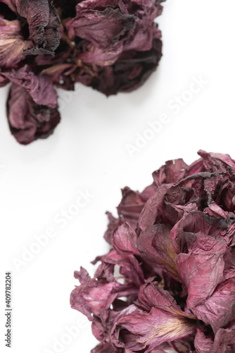 Dried red hibiscus rose flower on a white background. Greeting or invitation card, top view, flat lay, copy space.